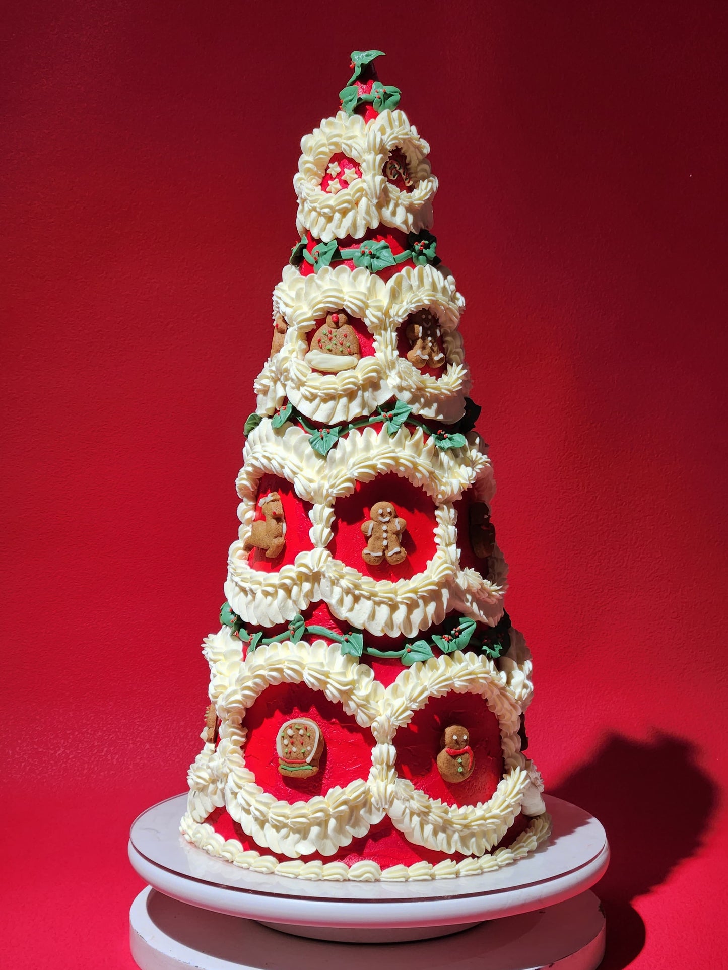 Decorative Christmas tree cake with gingerbread men on a red background
