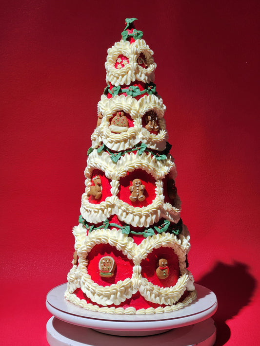 Decorative Christmas tree cake with gingerbread men on a red background